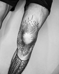 a man's arm with an intricate tattoo design on the left side of his leg