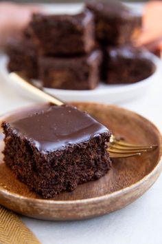 two plates with brownies on them, one has a bite taken out of it