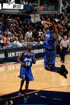 two basketball players jumping up to dunk the ball