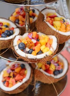 several trays filled with fruit on top of a metal platter next to each other