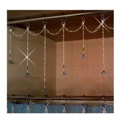 some lights hanging from the side of a window in a room with curtains and curtain rods