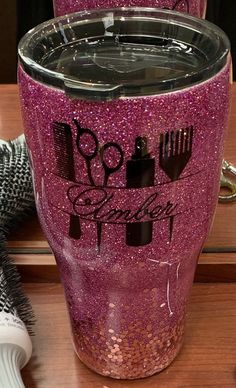 two purple glittered tumblers sitting on top of a wooden table