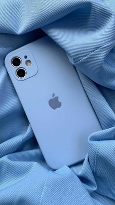 an iphone is laying on top of a blue blanket with its camera lens opened up