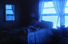 a bed sitting next to a window in a room