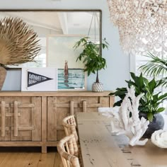 a dining room table with chairs and plants on top of it in front of a large mirror