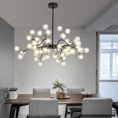 a dining room table with chairs and a chandelier hanging from it's ceiling