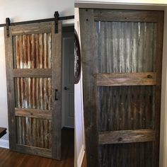 two wooden doors with metal slats on them in the same room, one is open and the other closed