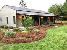 a house with a covered porch and landscaping around it