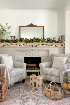 a living room filled with furniture and a fire place covered in greenery next to a fireplace