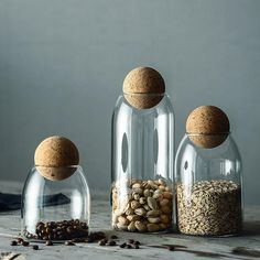 three glass jars filled with nuts and seeds