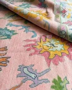 a pink and green rug with flowers on it