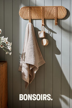 a towel hanging on the side of a wooden wall next to a potted plant