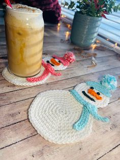 a drink sitting on top of a wooden table next to a snowman coasters