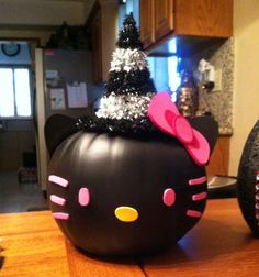 a black hello kitty pumpkin with a pink bow on top