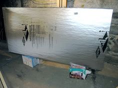 a large metal box sitting on top of a cement floor next to a brick wall