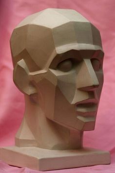 a paper sculpture of a man's head on a pink background