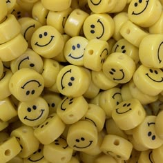 yellow smiley face beads with black eyes and mouths are shown in close up view on the surface