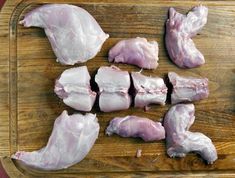 several pieces of raw chicken on a cutting board