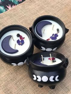 three black candles with white and purple flowers on them