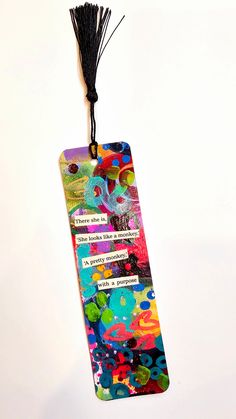 a colorful bookmark with a tassel hanging from it