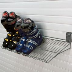 there are many pairs of skis hanging on the rack in front of the garage door