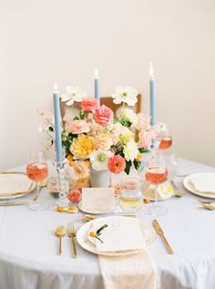 the table is set with flowers and candles