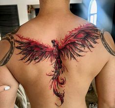 the back of a man's chest with a red and black bird tattoo on it