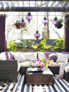 an outdoor living room with purple and white decor