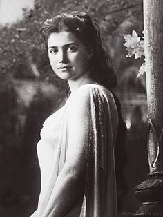 black and white photograph of a woman standing next to a tree