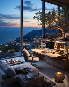 a living room filled with furniture and a large window overlooking the ocean at night time