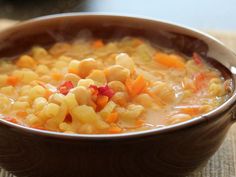 a brown bowl filled with soup on top of a table