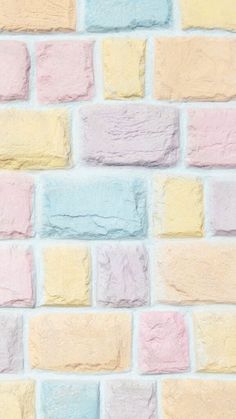 a brick wall with pastel colors painted on the side and in different directions to make it look like bricks