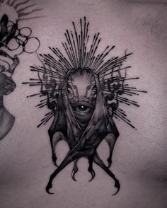 a man's chest with an alien tattoo on the side and his face in the center