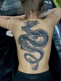 a woman with a dragon tattoo on her back