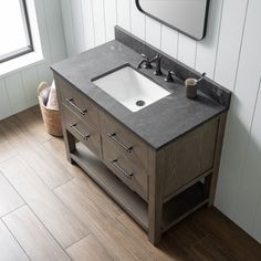 a bathroom sink sitting under a mirror next to a wooden cabinet and counter top in front of a window