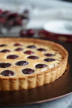 a pie with cherries on it sitting on a plate