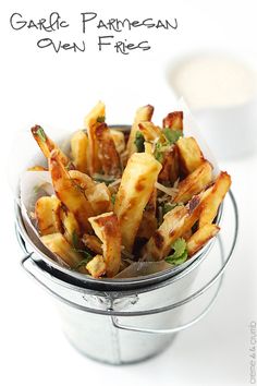 garlic parmesan oven fries in a bucket with ranch dressing on the side and text overlay that reads garlic parmesan oven fries