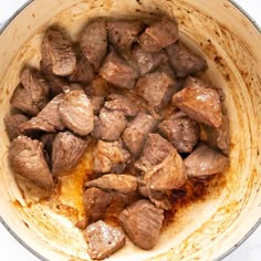 some meat is cooking in a pot on the stove top and it looks like they have been cooked