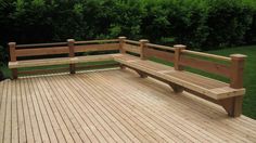 two wooden benches sitting on top of a wooden deck next to grass and trees in the background