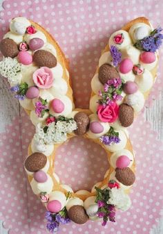 a letter made out of doughnuts with flowers and eggs on it, sitting on a polka dot surface