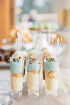 four desserts in small cups on a table