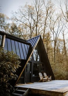 a wooden deck in front of a house surrounded by trees