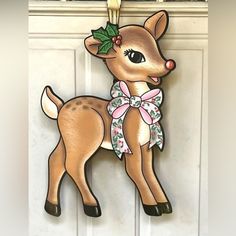 a christmas ornament hanging on a door with a deer decoration attached to it