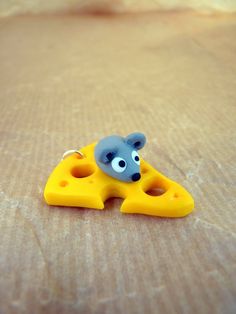 a yellow and blue toy mouse sitting on top of a piece of paper with holes in it