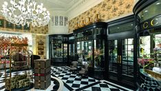 the interior of a store with black and white checkered flooring, chandelier and windows