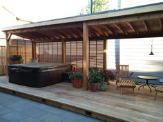 a hot tub sitting on top of a wooden deck next to a table and chairs