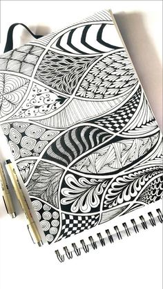 a spiral notebook with black and white designs on it