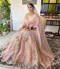 a woman in a pink bridal gown sitting on a chair