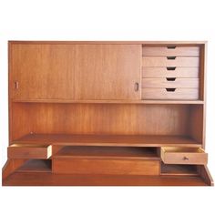 a wooden desk with drawers and shelves on the bottom shelf, against a white background