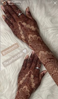 two hands with henna tattoos on them